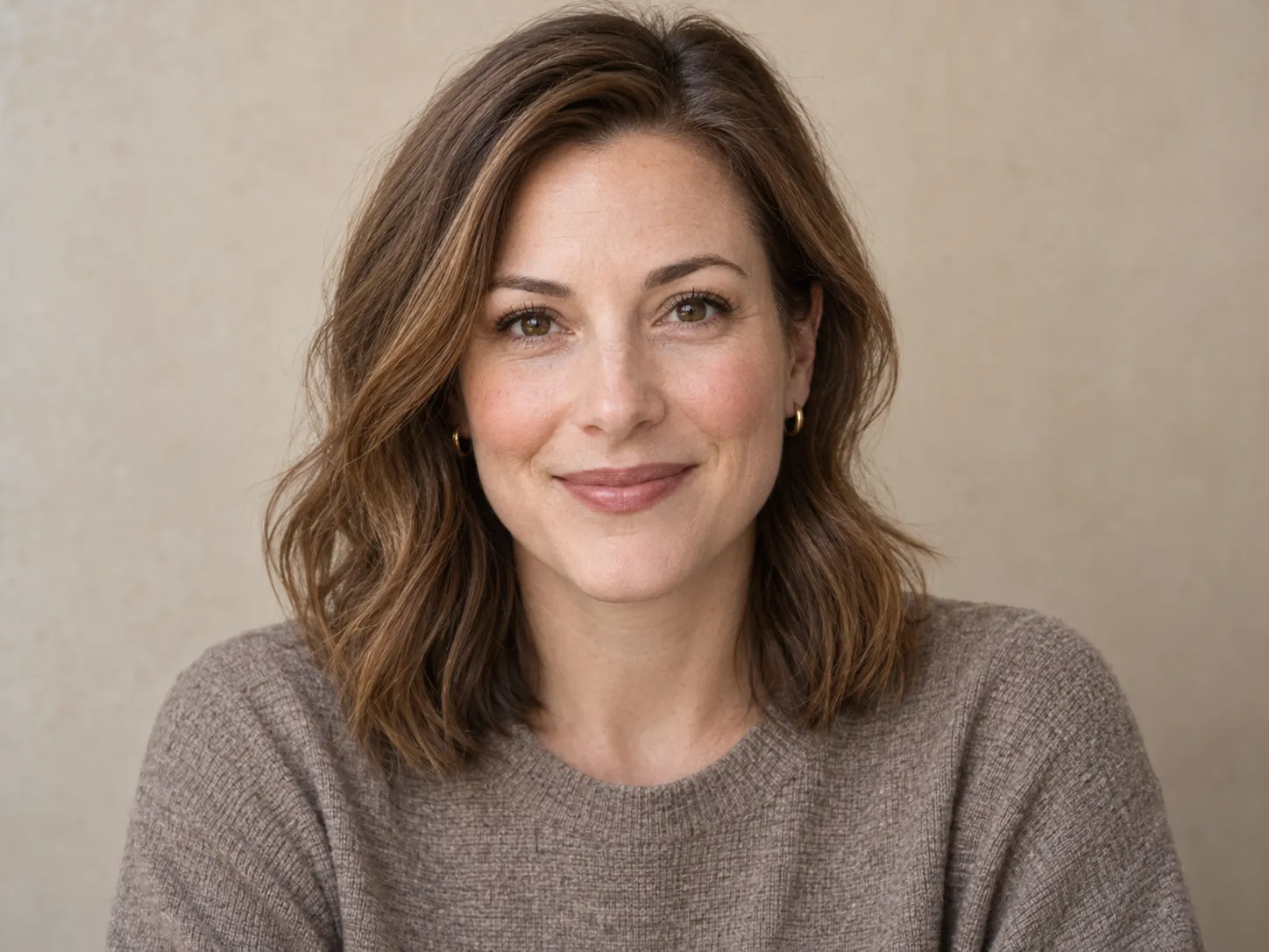 Headshot against a soft warm beige wall
