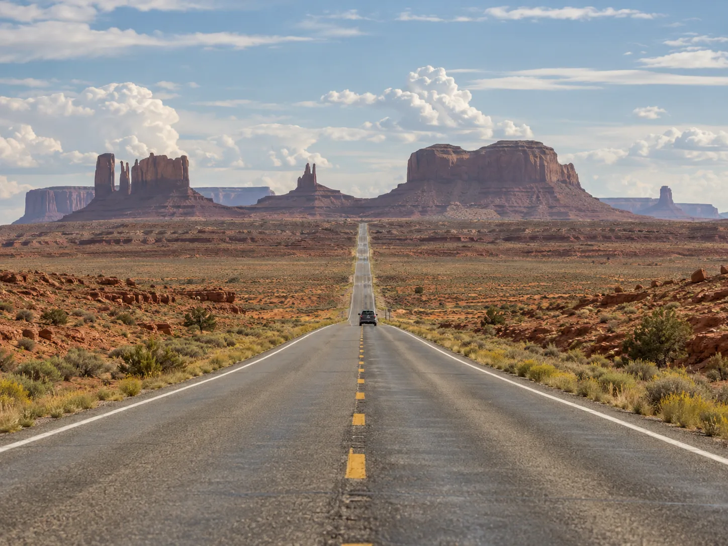 Road trip photo of an empty highway through red desert